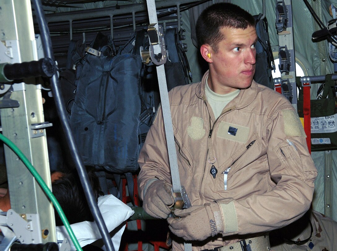 Airman 1st Class Bryce Bishop, 455th Expeditionary Aeromedical Evacuation Flight medical technician, secures a litter patient into a C-130 during an aeromedical evacuation mission from Bagram Airfield, Afghanistan. Airman Bishop is deployed from the Wyoming National Guard's 187th Aeromedical Squadron, Cheyenne, Wyo. (photo by Staff Sgt. Craig Seals)