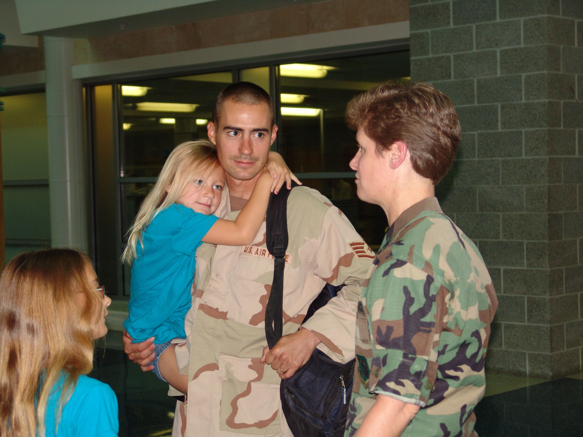 EGLIN AIR FORCE BASE, Fla.-- Staff Sgt. Brad Mitchell, 96th Logistics Readiness Squadron, talks to Col. Theresa Giorlando, 96th Mission Support Group commander, after returning from deployment.  His daughters, Katlyn and Myla, look on.  Sergeant Mitchell, and other members of the squadron, were deployed for almost nine months to Kandahar, Afghanistan, as convoy drivers. Master Sgt. Gregory Pocaigue, Tech Sgts. Lorri Mayes and Travis Laws and  Senior Airmen Joseph Fougerousse, Tarrick Jackson and Kurt Weiss also returned home. (Photo by Lois Walsh)                        