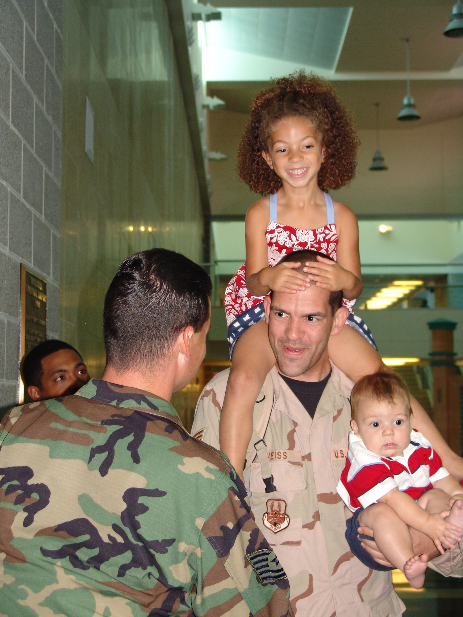 EGLIN AIR FORCE BASE, Fla.--Senior Airman Kurt Weiss, 96th Logistics Readiness Squadron, is welcomed home by his children, Jordan and Isaiah, June 23. Airman Weiss, and other members of the squadron, were deployed for almost nine months to Kandahar, Afghanistan, as convoy drivers. Master Sgt. Gregory Pocaigue, Tech Sgts. Lorri Mayes and Travis Laws, Staff Sgt. Brad Mitchell and  Senior Airmen Joseph Fougerousse and Tarrick Jackson also returned that day. (Photo by Lois Walsh) 