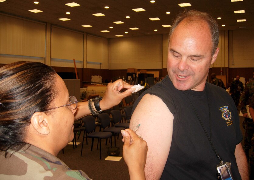 ANDREWS AIR FORCE BASE, Md. -- Lt. Col. Naomi Osborne, 459th Aeromedical Evacuation Squadron deputy chief nurse, immunizes Master Sgt. Fred Wilson, 459th Aircraft Maintenance Squadron communications and navigation systems craftsman, during an outprocessing line June 23. Members of the 459th Air Refueling Wing completed mobility line tasks prior to their deployment to Incirlik Air Base, Turkey. (U.S. Air Force photo/Lt. Col. Mike Laughton)