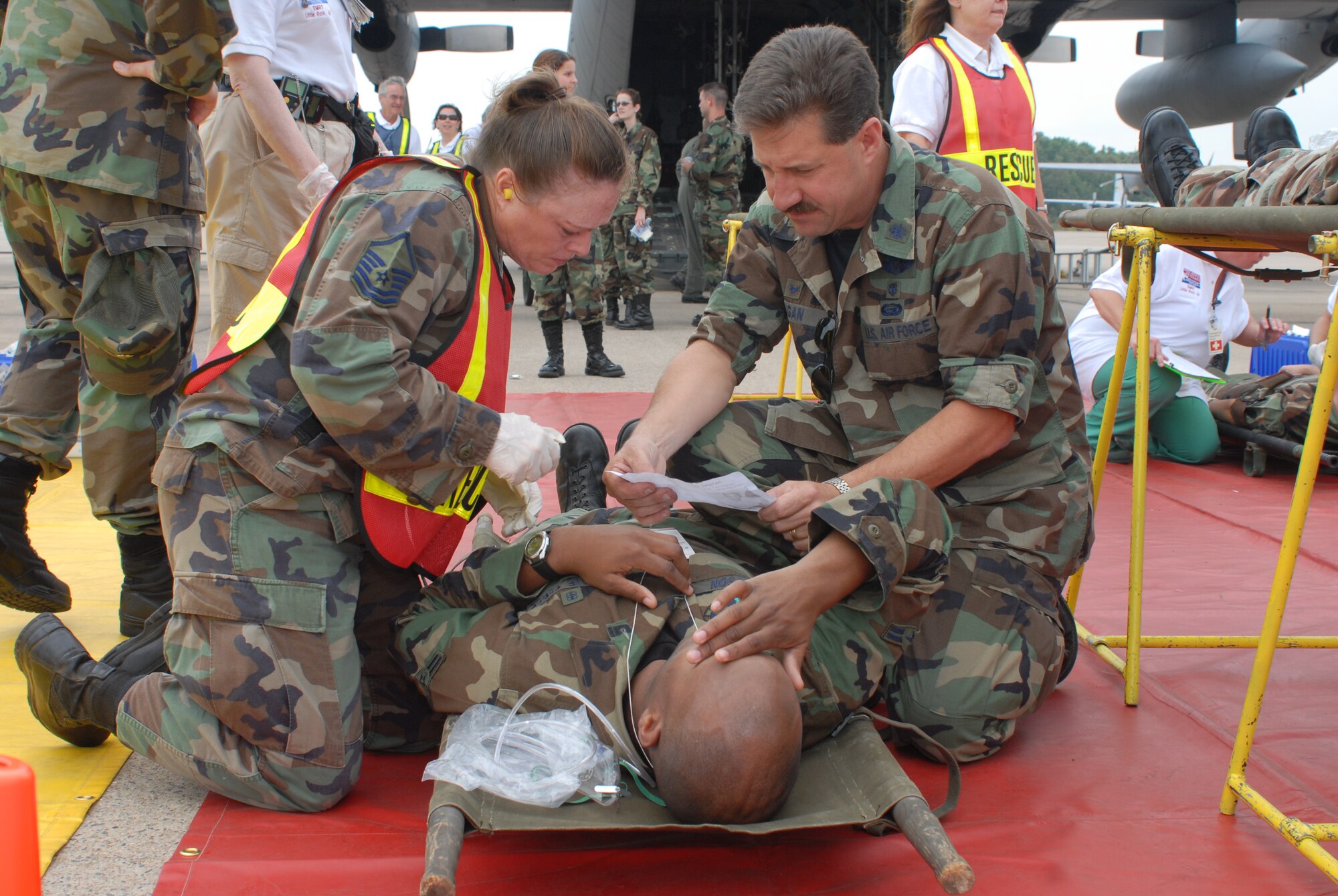 Master Sgt. Laura Marshall-Gish, 189th Medical Group Medical Technician Craftsman, and Lieutenant Colonel John Dugan, Commander of the 189th Medical Group, simulate treating Airman First Class Anthony Watson, 314th Medical Group Health Service Manager Apprentice, during a hurricane evacuation training exercise, at Little Rock Air Force Base, Ark., June 11, 2007. During the exercise, active duty and national guard airmen at LRAFB teamed up with local Veterans Affairs Emergency staff for a Major Accident Response Exercise to become better prepared for future hurricane or disaster evacuations. (U.S. Air Force photo by Airman First Class Jim Araos)