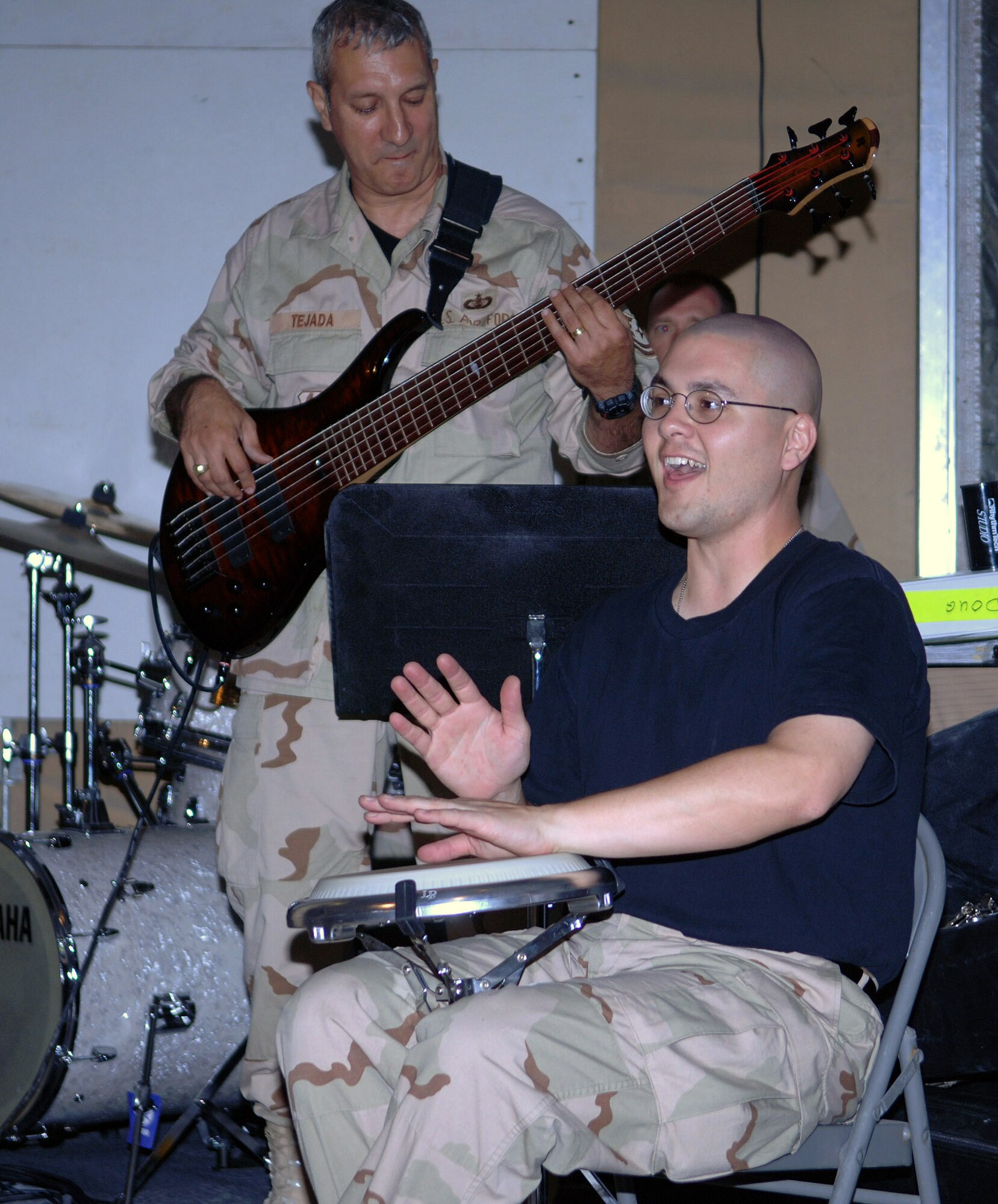 Tech. Sgt. Doug Tejada (background) and Staff Sgt. Timothy Shaw get into the groove as the band played some salsa music during an impromptu performance June 19 at Bagram Air Base, Afghanistan. The U.S. Central Command Air Forces Band played for the Airmen of the 455th Air Expeditionary Wing in the recreation tent at Camp Cunningham. Sergeant Tejada is a bass player and Sergeant Shaw is the band percussionist. (U.S. Air Force photo/Staff Sgt. Craig Seals)