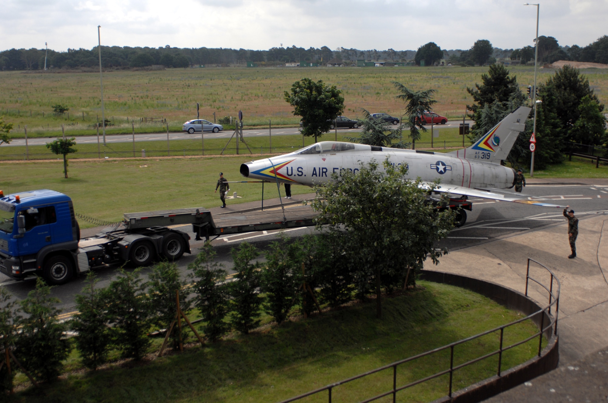 A 48th Fighter Wing Logistic Readiness Squadron truck carries the Gate 1 F-100 display aircraft to its home for the next five weeks in the Liberty paint barn June 23. The move involved more than seven base agencies ranging from Wing Safety, Logistics Readiness Squadron and EMS. (U.S. Air Force photo by Staff Sgt. Christopher Campbell.)
