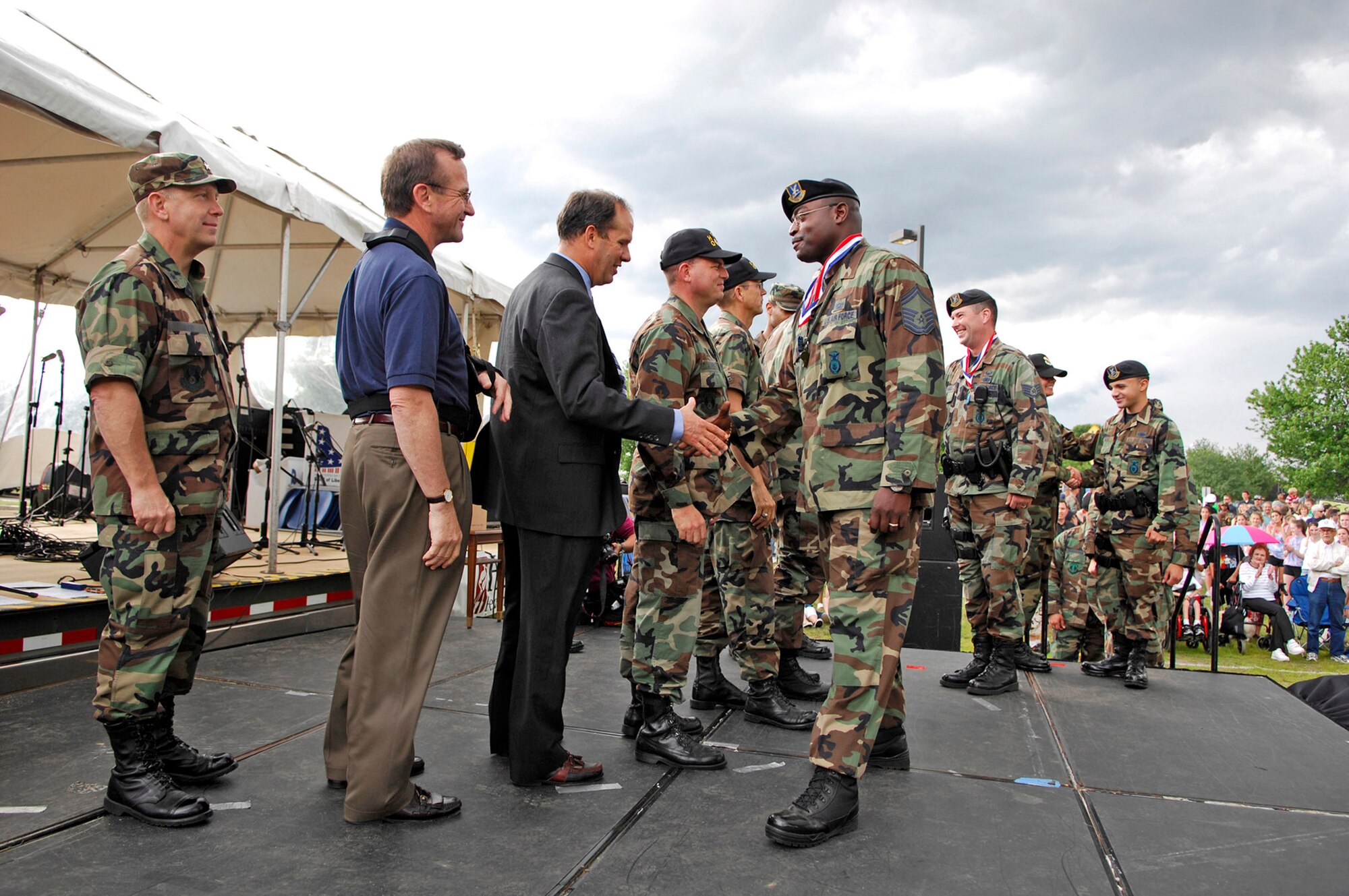 Senior Master Sgt. Woodrow Carter shakes hands with Bruce Hevey during Hanscom's Heroes' Homecoming June 22 at Hanscom Air Force Base, Mass. Base leaders lined the stage to formally welcome home more than 60 servicemembers who deployed within the last six months. Hundreds of base members, family and friends gathered during the ceremony. Sergeant Carter is assigned to the 66th Security Forces Squadron and Mr. Hevey is the 653rd Electronic Systems Wing director. (U.S. Air Force photo/Mark Wyatt)