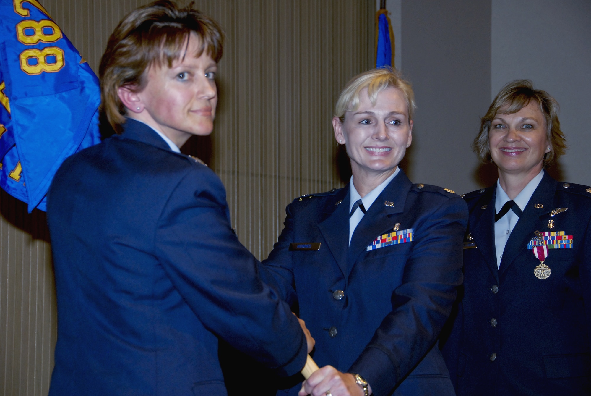 Lt. Col. Robie Hughes,  incoming 383rd Training Squadron Commander, accepts the guidon from 882nd Training Group Commander Col. Nancy Dezell during the 383rd Training Squadron change-of-command ceremony. (U.S. Air Force photo/Sandy Wassenmiller)