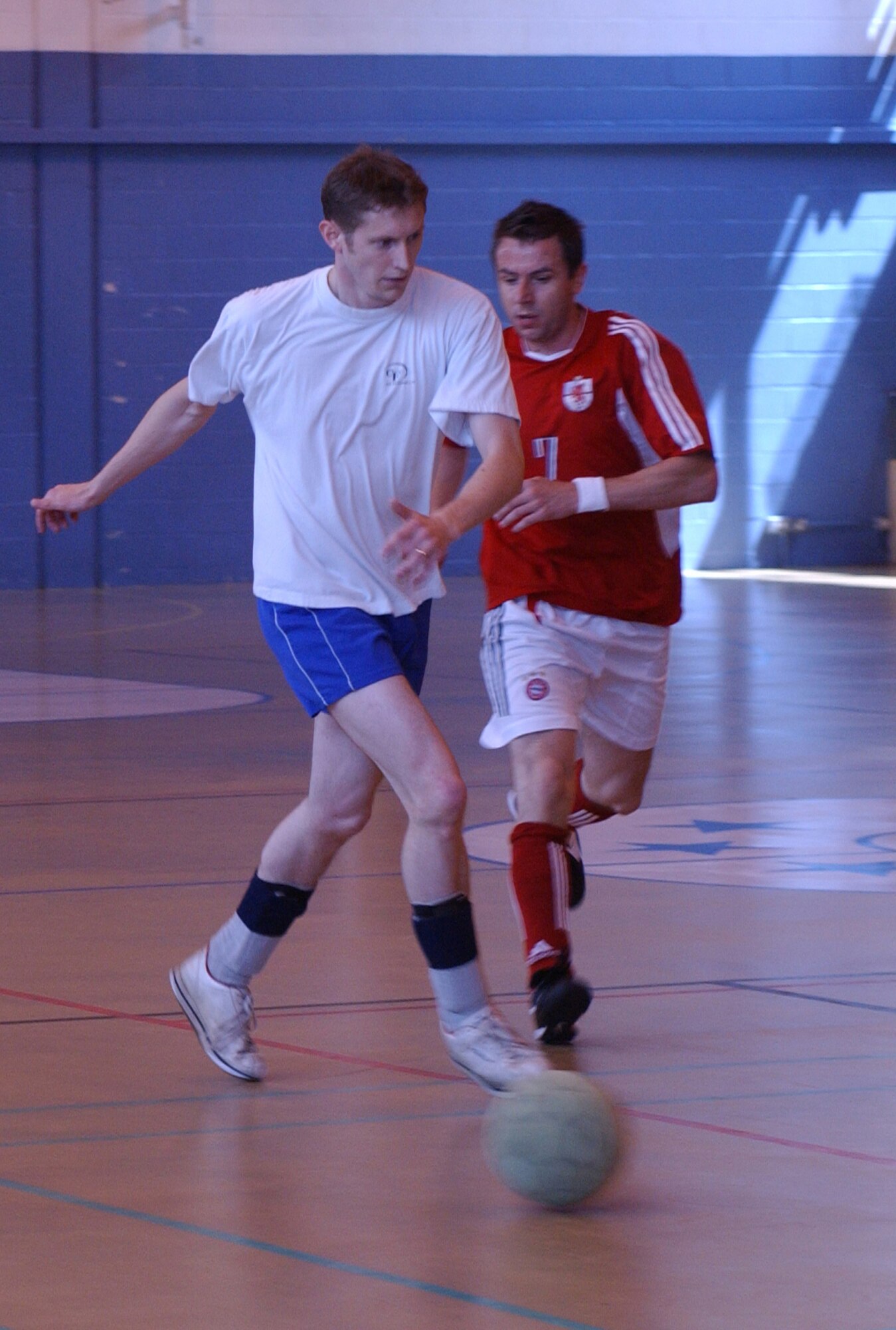 Match winner Darren Odey, goes past Marc Allen as the 100th Civil Engineer Squadron defeated the 727tth Air Mobility Squadron 3-2 in the intramural soccer championship at the Northside gym, June 22. (Air Force photo by Airman Brad Smith)