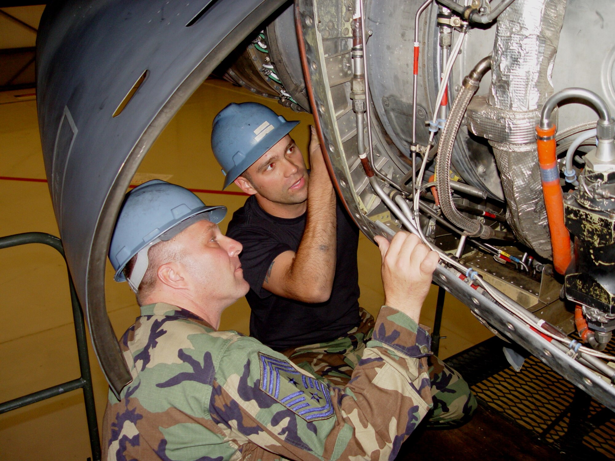Chief Master Sgt. Jeffrey Moser, the new 352nd Special Operations Group command chief master sergeant, left, is guided through the inner workings of an Allison T56-A-15 turboprop engine by Staff Sgt. Joshua Calton, 352nd Maintenance Squadron. Each aircraft needs four to power the MC-130P Combat Shadows and the MC-130H Combat Talon IIs special operations forces air taskings and mission sets. (U.S. Air Force photo by Master Sgt. Dennis Brewer)