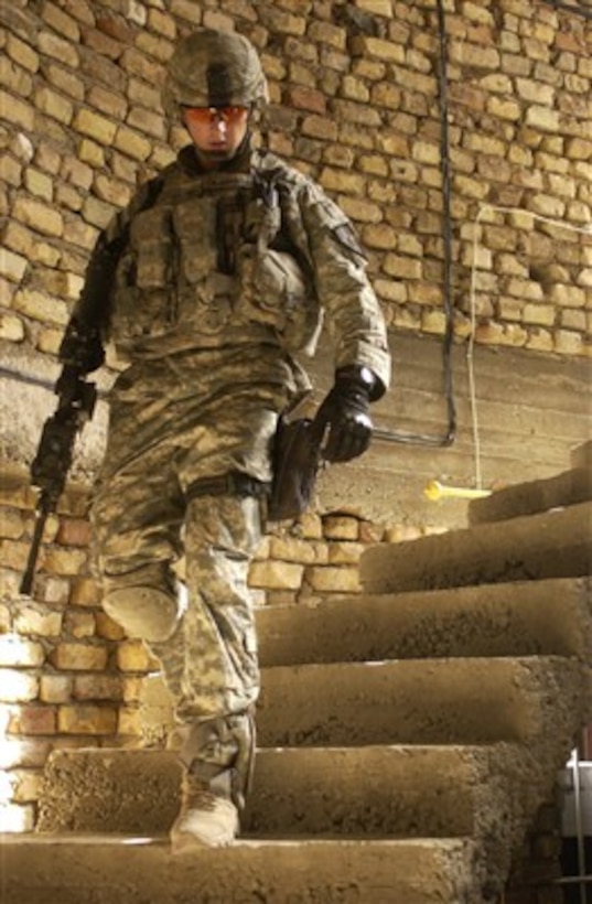 U.S. Army Sgt. Jake Desmarais descends a staircase after searching the roof of a house for explosive devices in Dora, Iraq, on June 21, 2007.  Desmarais is with Charlie Company, 2nd Battalion, 3rd Infantry Regiment out of Fort Lewis, Wash.  
