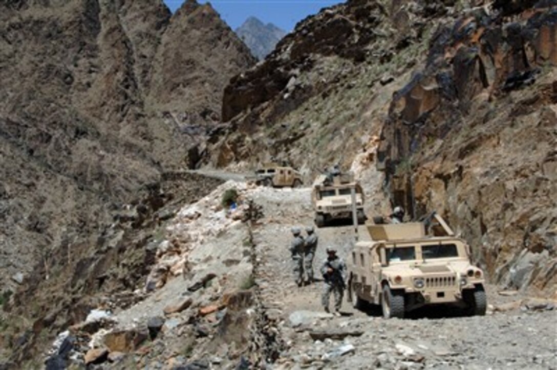 Soldiers of the Kalagush Provincial Reconstruction Team prepare to walk to the remote village of Balik during a patrol in the rugged Titin Valley in the Nuristan province of Afghanistan on June 14, 2007.  
