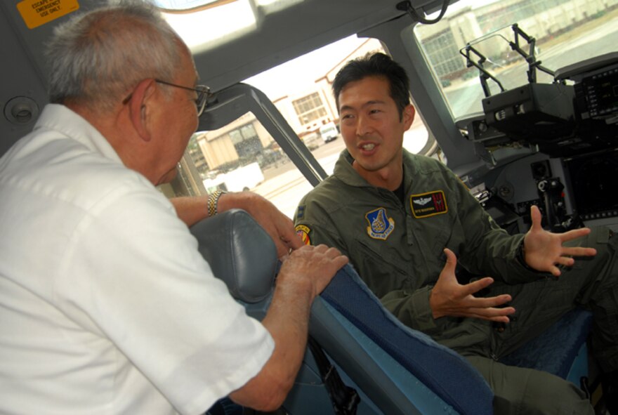 Capt. Skye Nakayama, C-17 pilot with the 204th Airlift Squadron, Hawaii Air National Guard, talks about the capabilities of the C-17 Globemaster with Sam Fujikawa, a World War II veteran who was a member of the 100th Infantry Battalion.  The 100th infantry Battalion celebrated its 65th anniversary on June 5.  The 100th Infantry Battalion is part of the 442nd Regimental Combat Team, a unit composed of mostly Japanese Americans who fought in Europe during World War II.  (USAF photo by Master Sergeant Kristen M. Higgins)                                