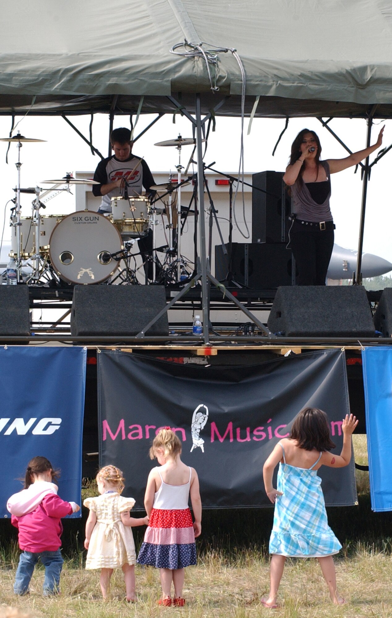 EIELSON AIR FORCE BASE, Alaska--Four young Maren fans dance in step to the lyrics of the band Maren June 23. Texas roots-rocker Maren performed various songs during the all-day event featuring aerial and ground demonstrations including flybys, simulated airfield attacks, and aerobatic maneuvers as well as concessions, live music and many aircraft displays. (U.S. Air Force photo by Senior Airman Justin Weaver)                     