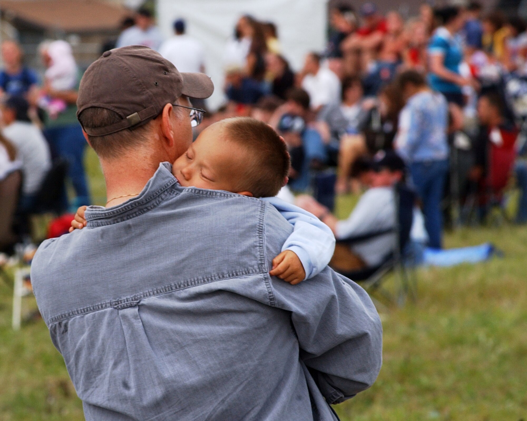 EIELSON AIR FORCE BASE, Alaska--Tuckered out from a long day of playing, a little boy sleeps on his dad's shoulder during the 2007 Soaring into Solstice Open House June 23 here. More than 25,000 people attended the all-day event featuring aerial and ground demonstrations including flybys, simulated airfield attacks, and aerobatic maneuvers as well as concessions, live music and many aircraft displays. (U.S. Air Force photo by Senior Airman Justin Weaver)