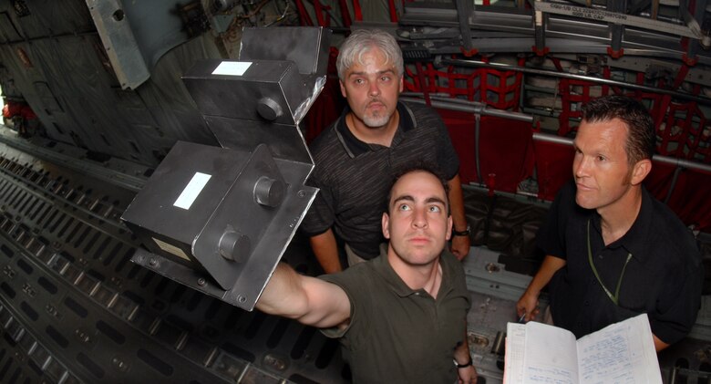 Engineer Jeremy Goldin holds a model of a new C-130 Hercules anti-skid system June 21 as he, hydraulics specialist Ronald Crabtree and engineer Todd Walker tour a C-130 June 21 at Little Rock Air Force Base, Ark.  The new anti-skid system is projected to be installed in C-130s in 2010. All three are from Hill Air Force Base, Utah. (U.S. Air Force photo/Airman 1st Class Steele Britton)