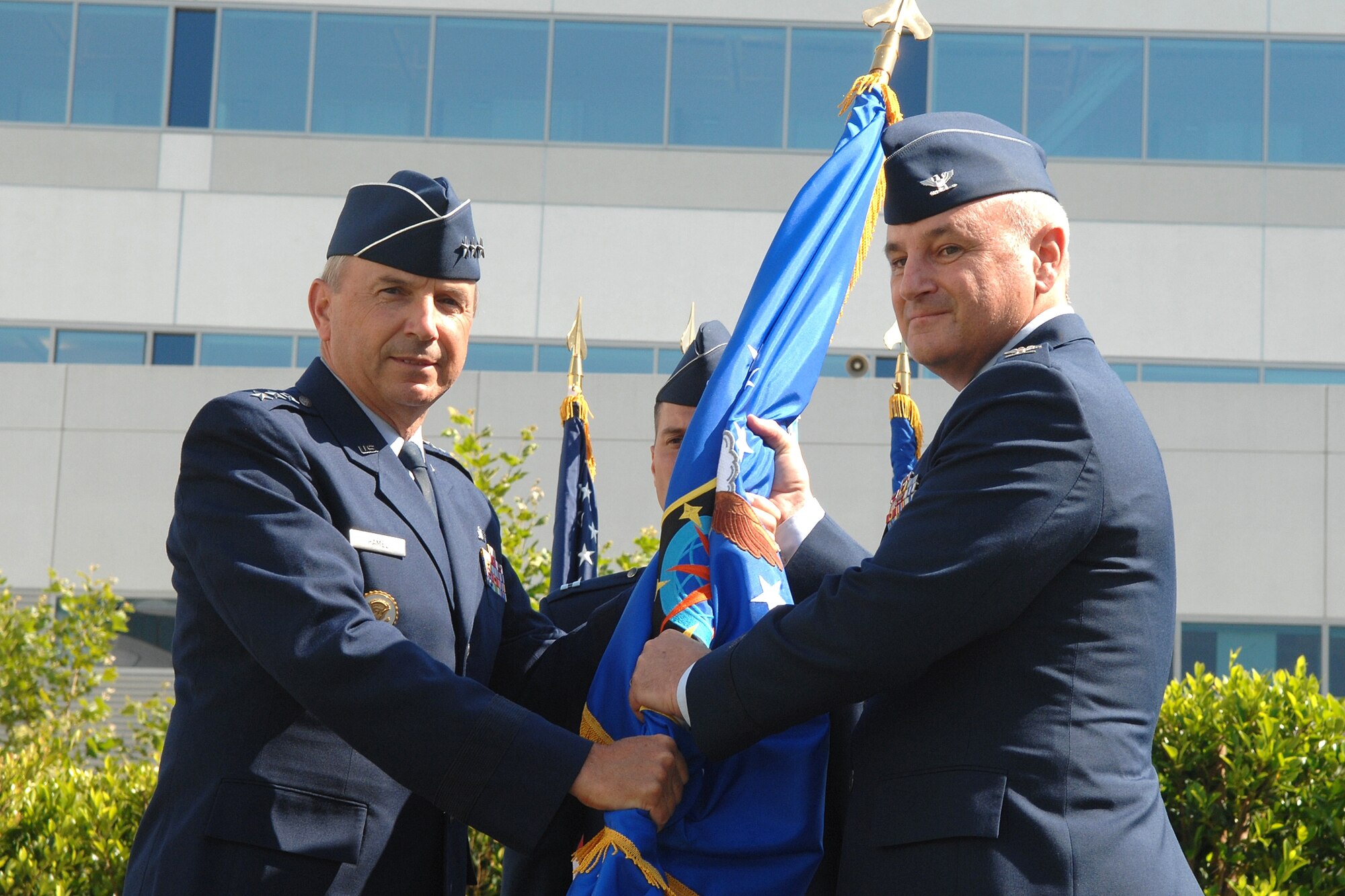 Col. David Madden, new GPS Wing commander, accepts the flag from Lt. Gen. Michael Hamel, SMC Commander, at the wing’s change of command ceremony held June 18. (Photo by Stephen Schester)