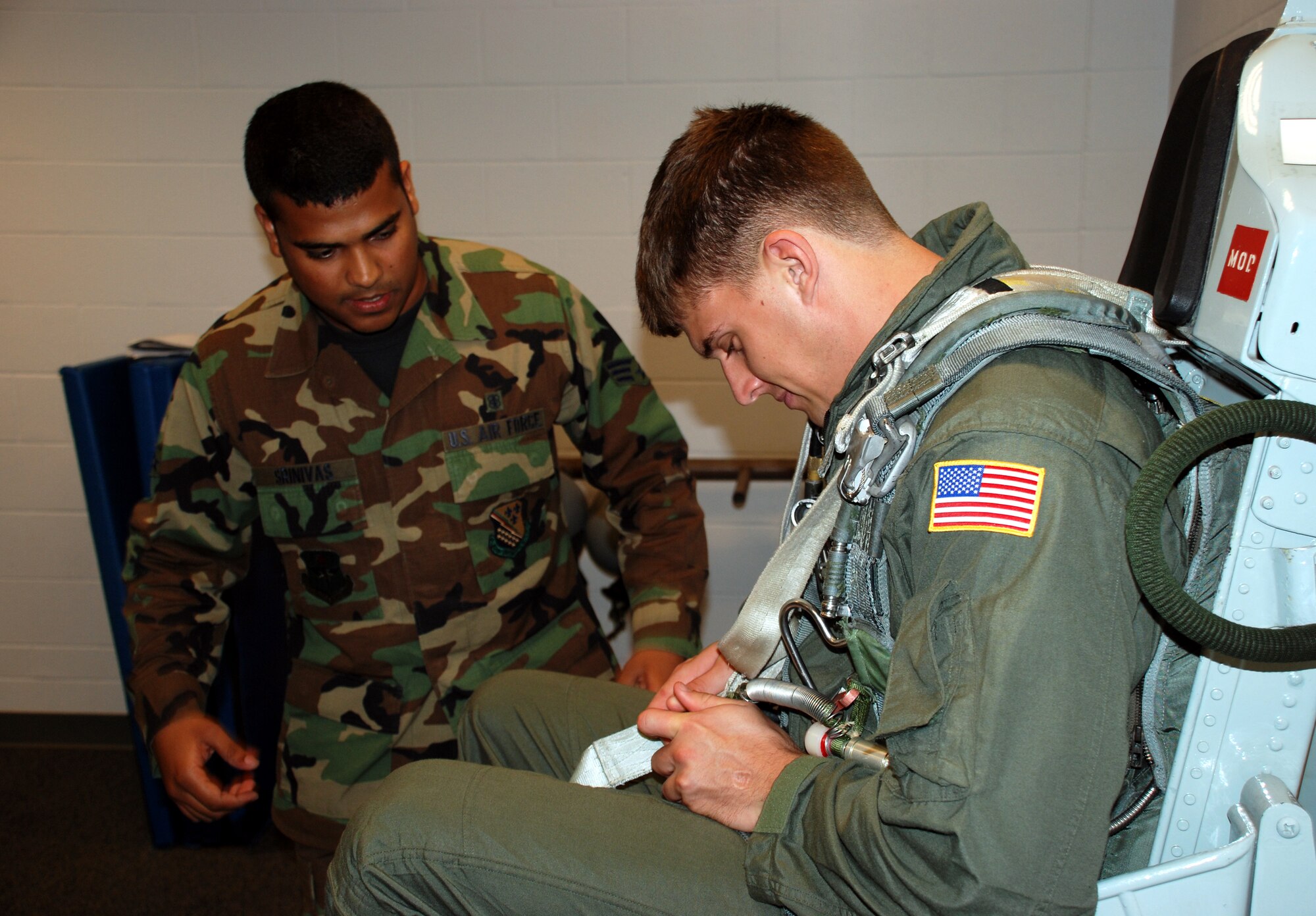 Senior Airmen Vivek Srinivas, 82nd Aerospace Medecine Squadron, walks Cadet 2nd Class Jeremy Fox, U.S. Air Force Academy, through aircraft ejection procedures June 7 during Operation Air Force. (U.S. Air Force photo/Airman 1st Class Jacob Corbin)