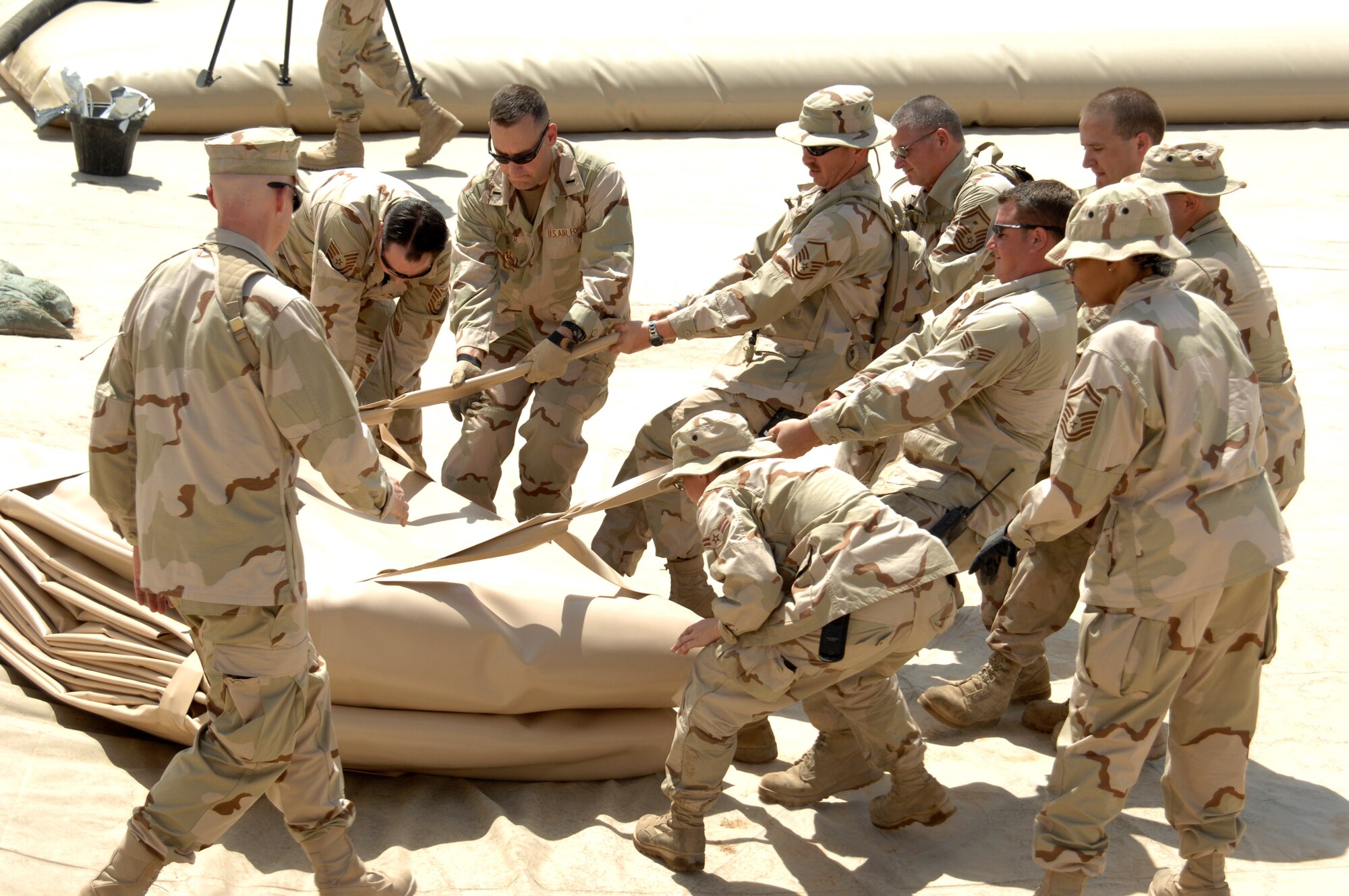 Airmen in the 506th Expeditionary Logistics Readiness Squadron pull a new fuel bladder into a fuel pit June 19 at Kirkuk Regional Air Base, Iraq.  The bladder will be filled with JP-8 jet fuel.  Fuel storage bladders are collapsible, flexible storage containers that provide temporary as well as long term fuel storage. (U.S. Air Force photo/Senior Airman Kristin Ruleau)