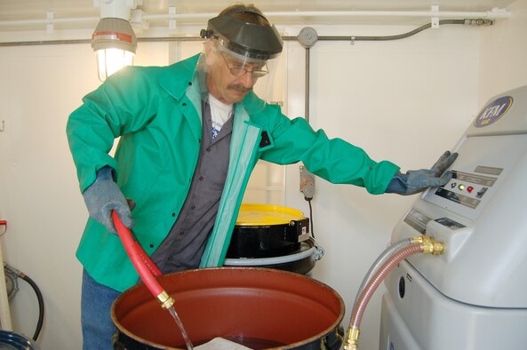 EGLIN AIR FORCE BASE, Fla. -- John Cecil, a 96th Logistics Readiness Squadron vehicle mechanic and the unit's environmental coordinator, runs their new antifreeze recycler.  Mr. Cecil lobbied to Eglin's Environmental Compliance branch to fund the purchase of this machine to save the base $6,000 annually in hazardous waste disposal and new antifreeze purchase costs, a "win-win" situation for both parties, Jim Reese, Eglin's pollution prevention coordinator, said.  Vehicle mechanics replace 1,200 gallons of antifreeze a year in their 1,600-vehicle fleet and can produce a barrel of new specification antifreeze in one hour using this machine versus three hours per barrel using their old and now defunct antifreeze recycler. (U.S. Air Force photo by Jerron Barnett)