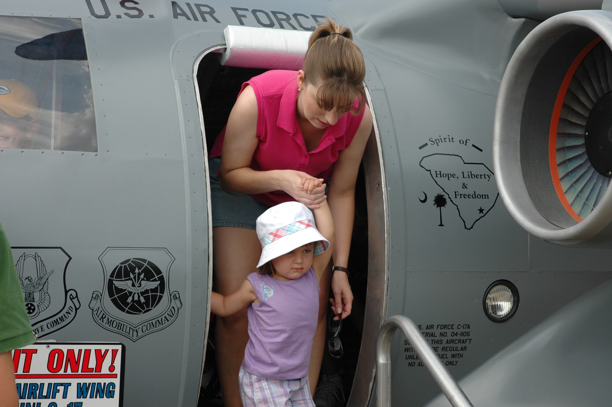 A mother and daughter exit the Mini C-17 on static display at Pittsburgh Air Reserve Base, PA,  in the “Wings Over Pittsburgh” airshow. (photo by Major Bill Walsh, USAFR)
