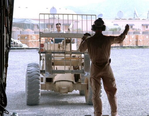 Senior Airman Patrick Keefe guides a forklift to the cargo ramp of a C-130 Hercules to unload palettes at Forward Operating Base Salerno, Afghanistan. Airman Keefe is a 774th Expeditionary Airlift Squadron loadmaster deployed from Wyoming's Air National Guard from Cheyenne, Wyo. (U.S. Air Force photo/Staff Sgt. Craig Seals) 