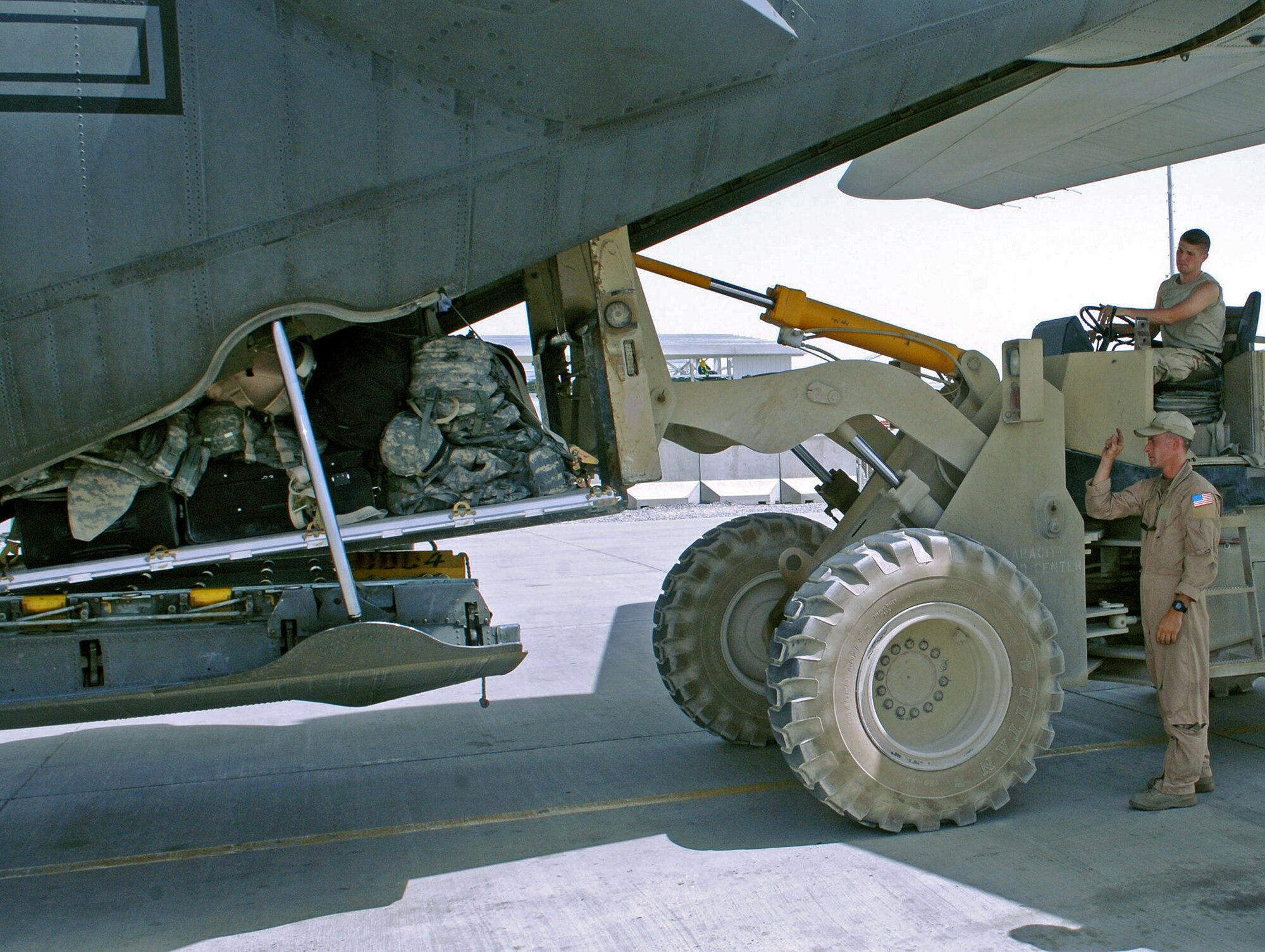 Senior Airman Patrick Keefe (far right) directs a forklift carrying passenger luggage into the cargo area of a C-130 Hercules at Kandahar Airfield, Afghanistan. Airman Keefe is a 774th Expeditionary Airlift Squadron loadmaster deployed from Wyoming's Air National Guard from Cheyenne, Wyo. (U.S. Air Force photo/Staff Sgt. Craig Seals) 