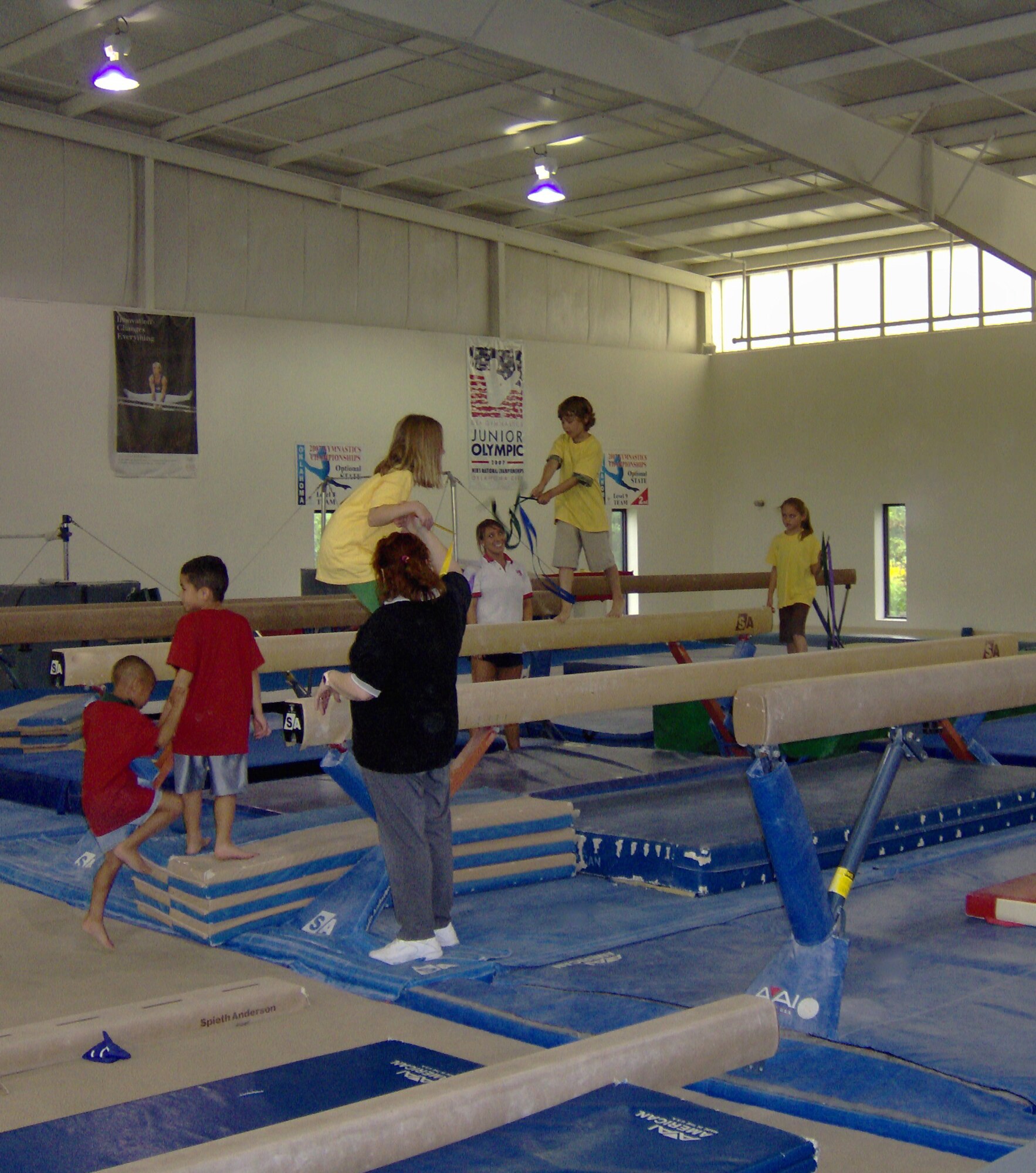Children in Vance Air Force Base's School Age program test their balance at the Bart Conner Gymnastics Academy, where they met two-time Olympic Champion Bart Conner, as well as Nadia Comaneci, who scored the first "Perfect 10" in 1976 and won five gold medals, three silver medals and one bronze medal over two Olympic Games.  
