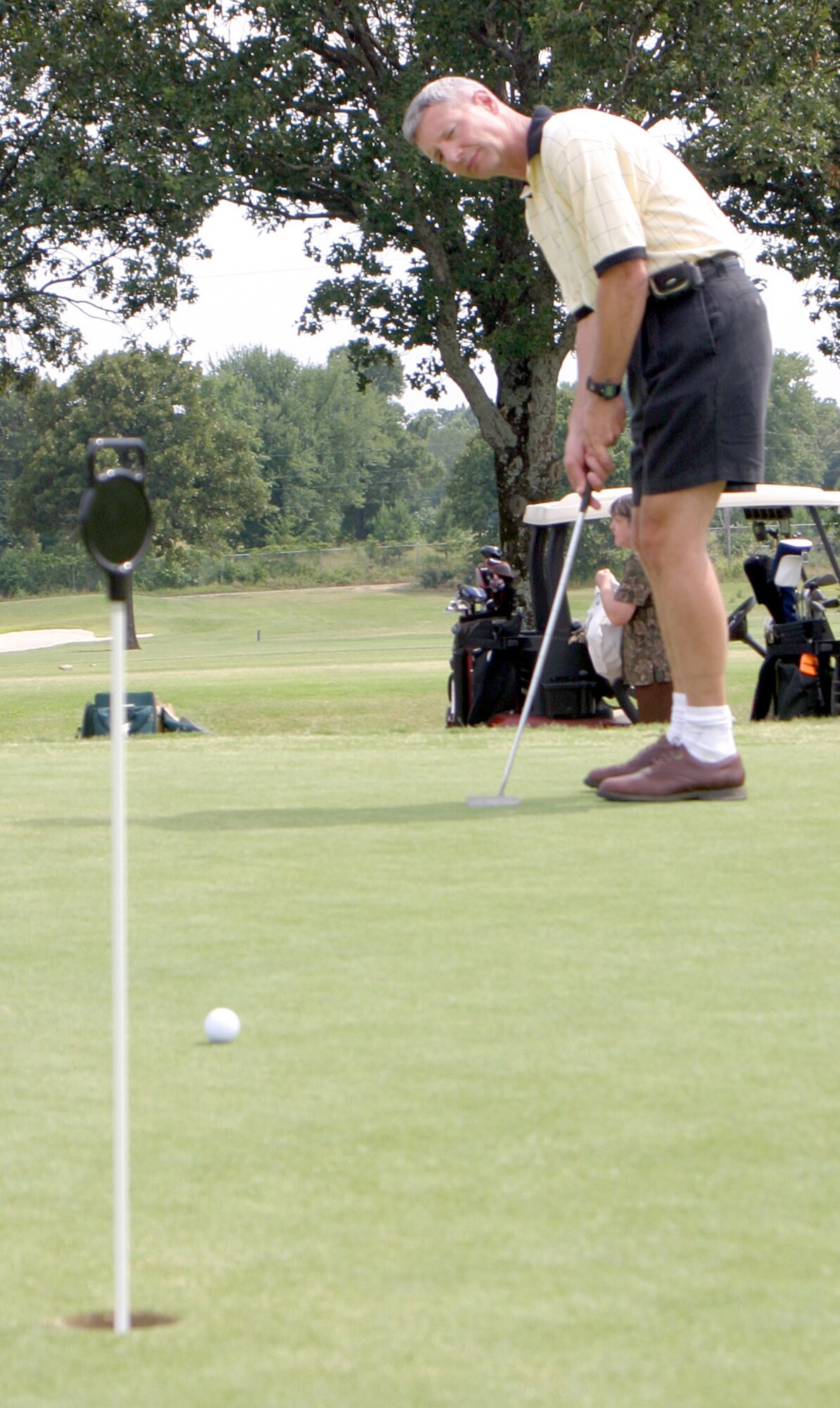 Col. Wayne Schatz, 314th AIrlift Wing commander, watches the line on his putt on the Deer Run Golf Course putting green June 22 after the ribbon cutting ceremony for the course's new greens. The event marked the opening of the new greens on all of Deer Run's 18 holes. (U.S. Air Force photo by Tech. Sgt. Arlo Taylor)