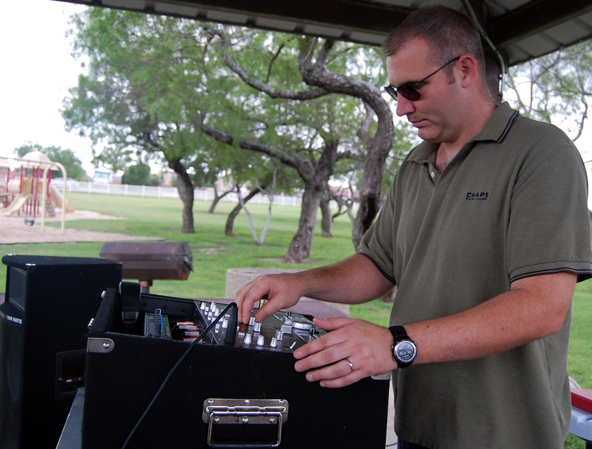 LAUGHLIN AIR FORCE BASE, Texas -- Staff Sgt. Matthew Cook, 47th Aeromedical Dental Squadron, helps set the atmosphere by playing music and helping people to get into the spirit of Laughlin's Second Annual Wild West Day June 22. Volunteers from all around Laughlin came out to the event to cook food, serve drinks, and help with games. 