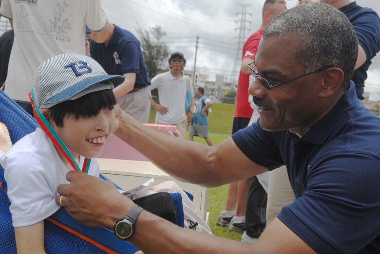 Yujiro Nakamura, Awase Special Needs School, receives his silver medal from Chief Master Sgt. Jack Johnson Jr., 18th Wing command chief, after competing in the softball throw event June 24.  More than 900 participants enjoyed this year’s Special Olympics at Kadena Air Base, Japan.
 (U.S. Air Force/Senior Airman Jeremy McGuffin)