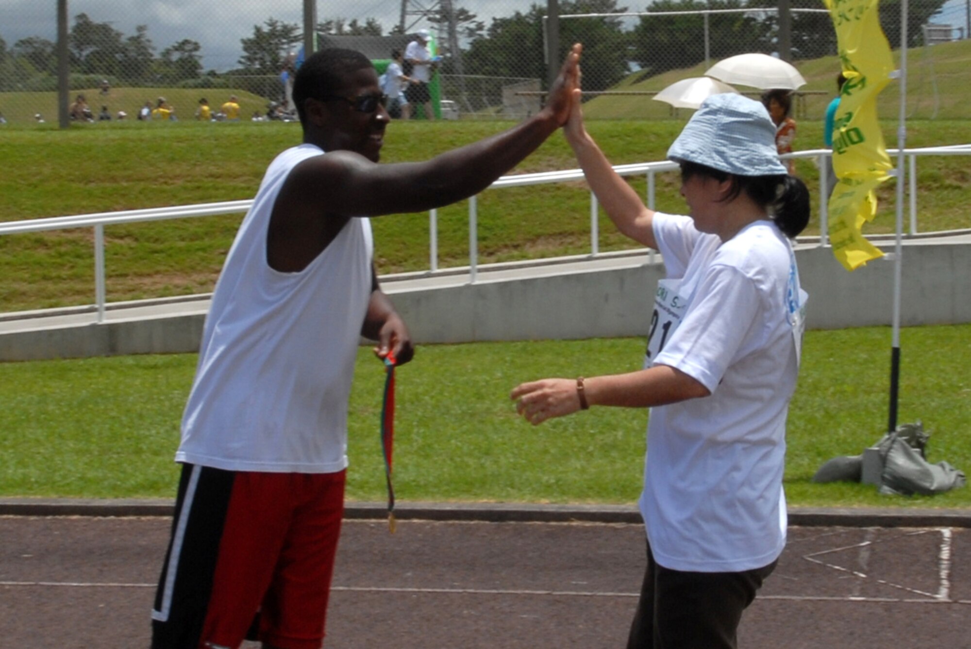 Senior Airman Hulon Polk, 18th Equipment Maintenance Squadron, high fives Kaori Shiroma, Friends House Workshop, as she completes her 200-meter dash during the Special Olympics held at Kadena Air Base, Japan, June 24.
(U.S. Air Force/Airman 1st Class Kasey Zickmund)
