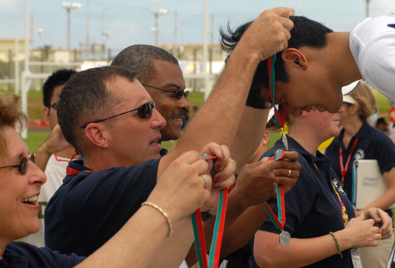 18th Wing Commander Brig. Gen. Brett T. Williams presents Taiki Tamaki, Ohira Special Needs School, a gold medal after completing the 20-meter dash during the Special Olympics held June 24 at Kadena Air Base, Japan.
 (U.S. Air Force/Airman 1st Class Ryan Ivacic)