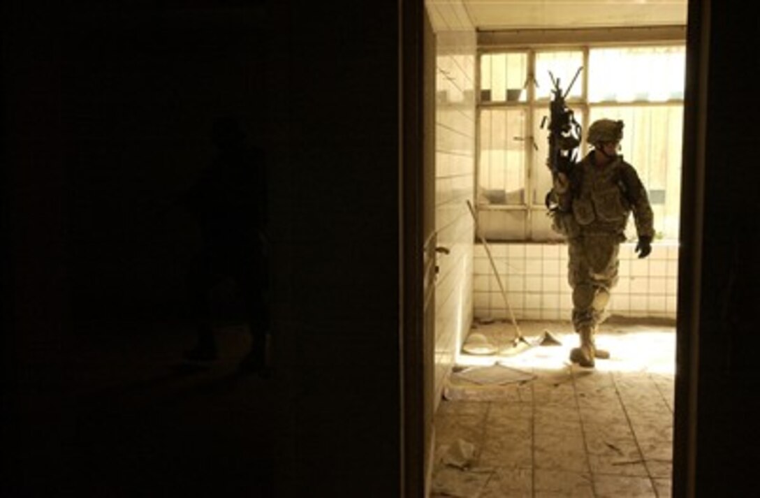 A soldier with the U.S. Army's 1st Battalion, 38th Infantry Regiment, 4th Stryker Brigade Combat Team, 2nd Infantry Division searches an abandoned house during a cordon and search in the Rashid district of Baghdad, Iraq, on June 21, 2007.  