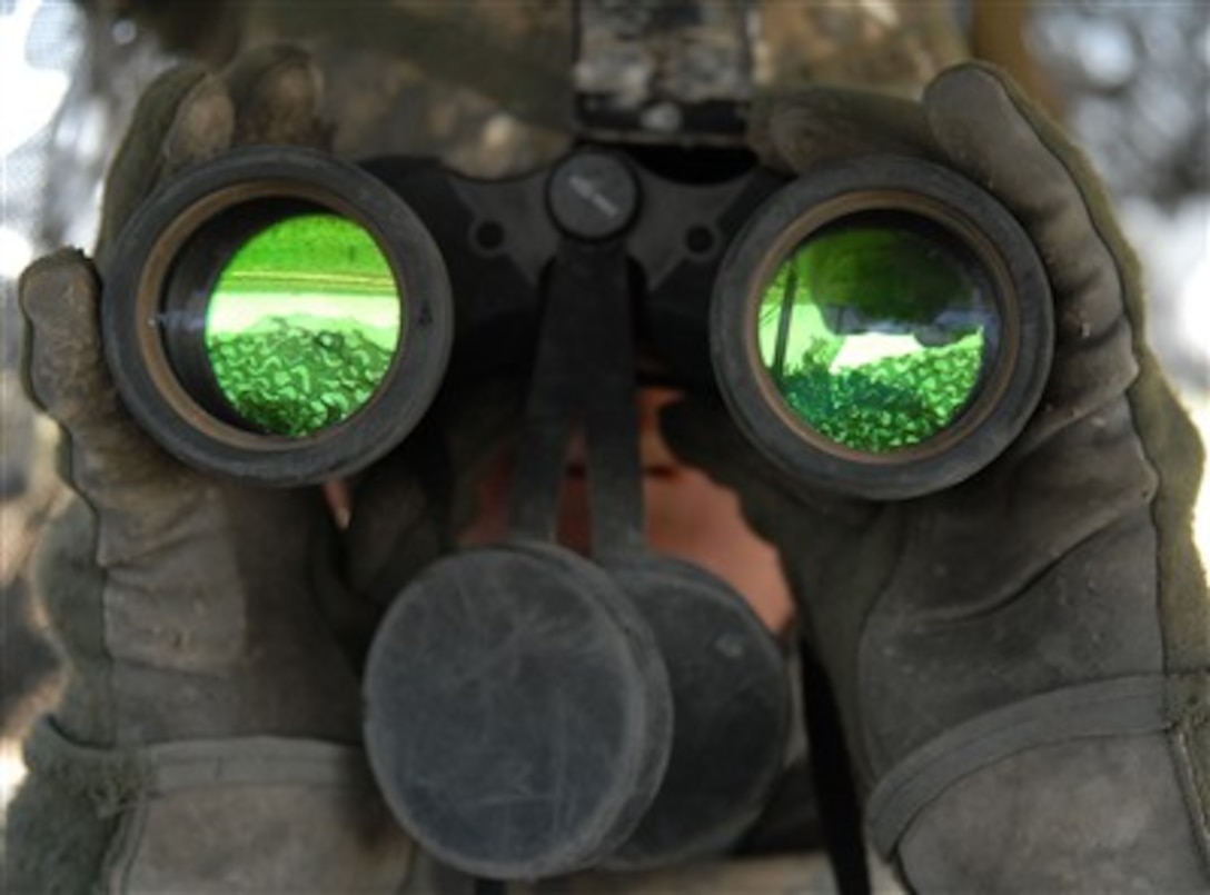 U.S. Army Spc. John Galebach uses binoculars to scan the horizon while standing rear air guard atop a Stryker vehicle in Baqubah, Iraq, on June 19, 2007. Galebach is assigned to Charlie Company, 2nd Battalion, 1st Infantry Regiment, 3rd Brigade Combat Team, 2nd Infantry Division.  