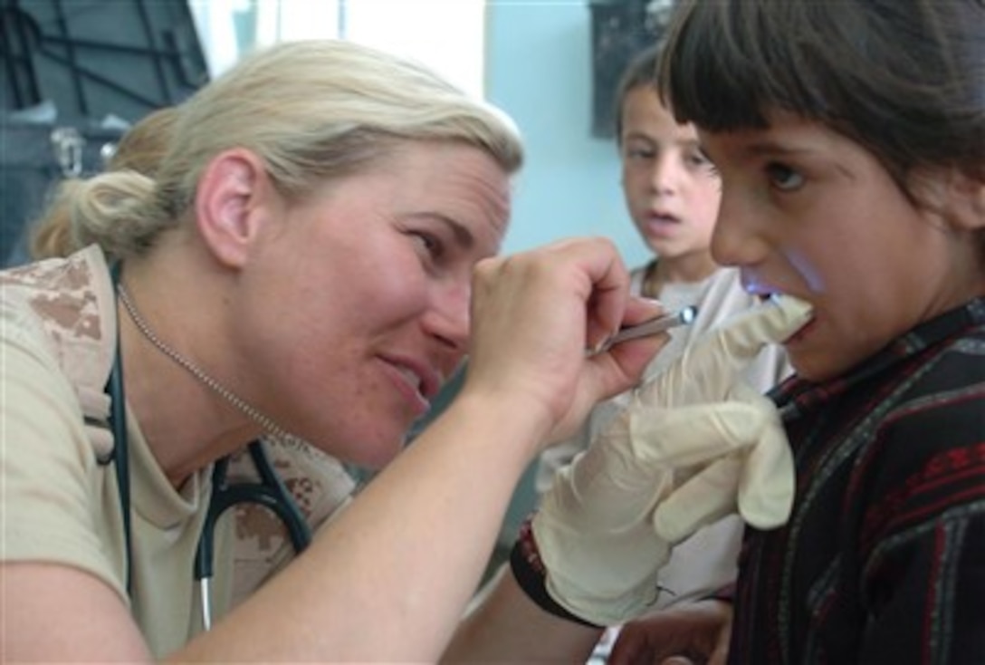 U.S. Navy Lt. Jennifer Rosen, doctor of general medicine, examines a local child during a medical engagement in the Nijrab district, Kapisa Province, Afghanistan. Medical staff saw more than 160 people.
