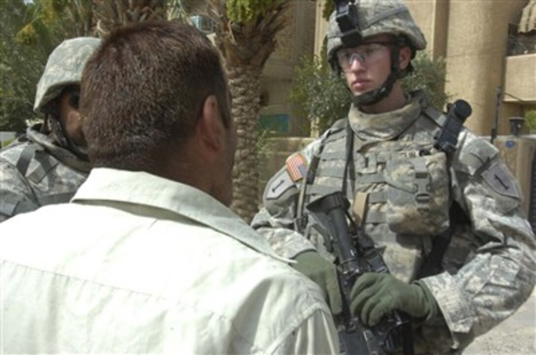 1st Lt. Eric Laflin, platoon leader for "Dirty" Platoon, Company Alpha, 9th Engineers, 2nd Brigade Combat Team, 1st Infantry Division from St. Paul, Minn., asks an Iraqi questions about an improvised explosive device attack that took place June 20 in southern Baghdad. 