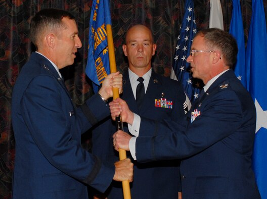 KADENA AIR BASE, Japan -- Brig. Gen. Brett T. Williams, 18th Wing commander, passes the guidon to the new 18th Medical Group commander, Col.  Frederick L. Schaefer, during a change of command ceremony here June 21. Col. Kelley Kash relinquished command and retired on the same day. (U.S. Air Force photo/A1C Kelly Timney)