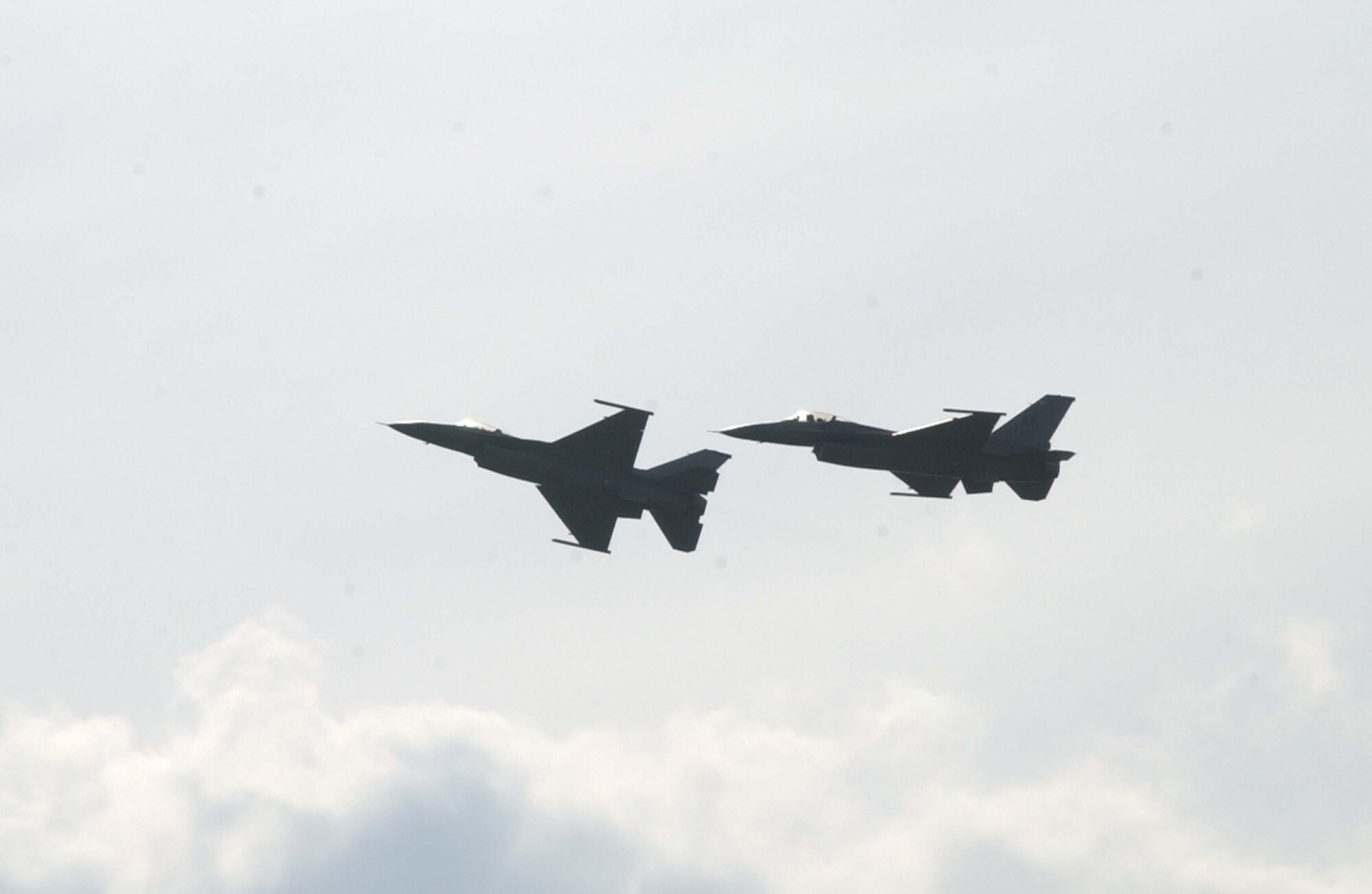 EIELSON AIR FORCE BASE, Alaska --  Two F-16's make a final pass during the relinquish of command of the 18th Fighter Squadron and the 355th Fighter Squadron June 23. The ceremony marked the de-activation of both squadrons to cap off the end of Eielson's first Open House. (U.S. Air Force photo by Airman 1st Class Christopher Griffin) (Released)