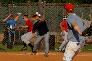 Harry Carnell, 437th Aerial Port Squadron, runs through first base safely as Matt Cunningham, 437th Operations Support Squadron, throws the ball to his teammate, Robert Sadwick during the game on base Tuesday. (U.S. Air Force photo/Airman 1st Class Nicholas Pilch) 
