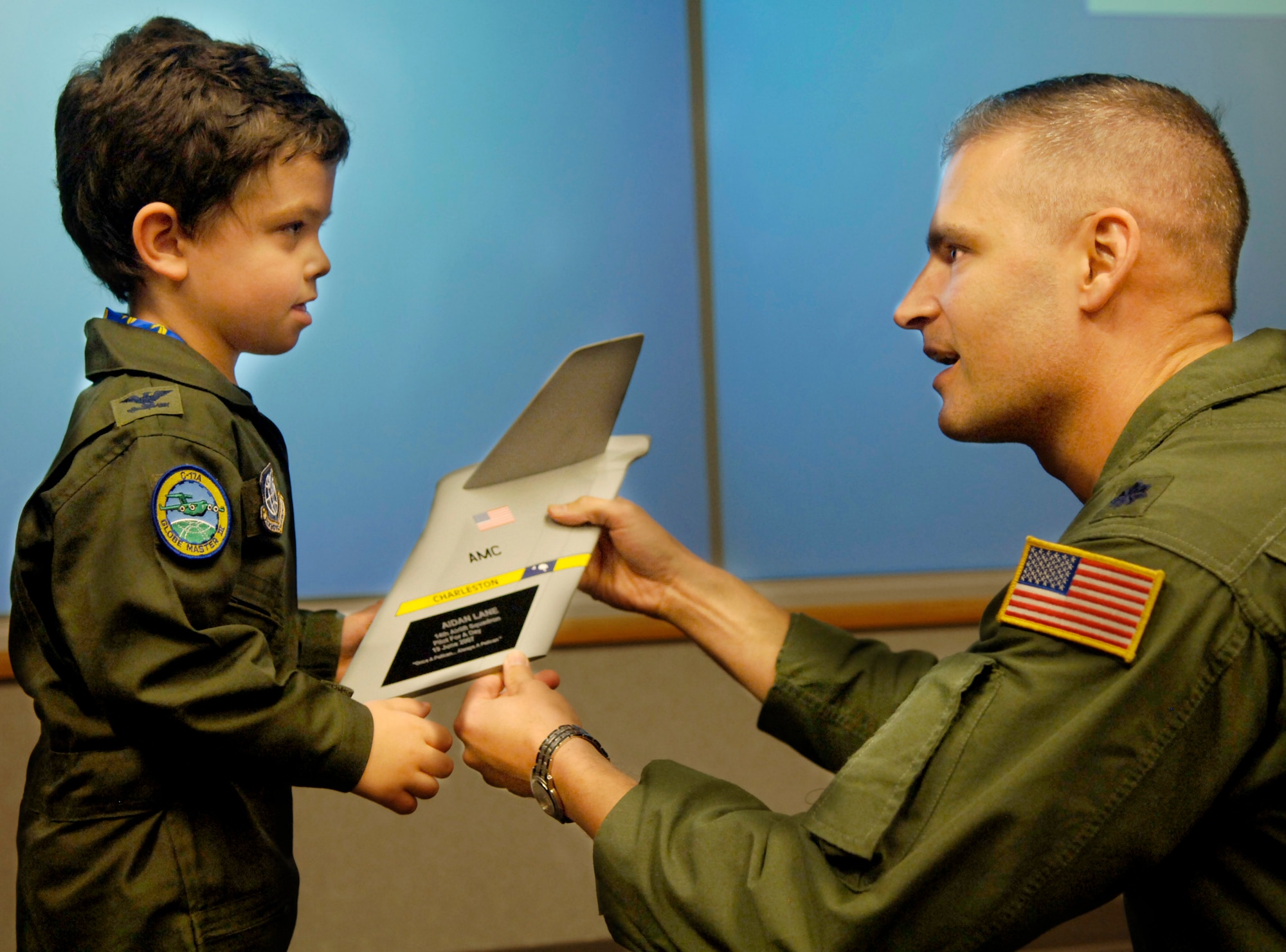 Aiden Lane, 5, son of Maj. Donald and Darii Lane, receives a plaque from Lt. Col. "Buddy" Czubaj, 14th Airlift Squadron commander, commemorating his Pilot for a Day experience June 19 at Charleston AFB. (U.S. Air Force photo/Airman 1st Class Nicholas Pilch) 

