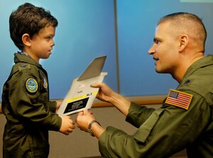 Aiden Lane, 5, son of Maj. Donald and Darii Lane, receives a plaque from Lt. Col. "Buddy" Czubaj, 14th Airlift Squadron commander, commemorating his Pilot for a Day experience June 19 at Charleston AFB. (U.S. Air Force photo/Airman 1st Class Nicholas Pilch) 

