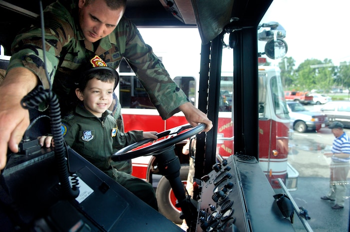 Staff Sgt. Van Smith, 437th Civil Engineer Squadron firefighter crew chief, gives Aiden Lane, 5, son of Maj. Donald and Darii Lane, a tour of the 437 CES Fire Department June 19 as part of the Pilot for a Day Program.(U.S. Air Force photo/Airman 1st Class Nicholas Pilch) 