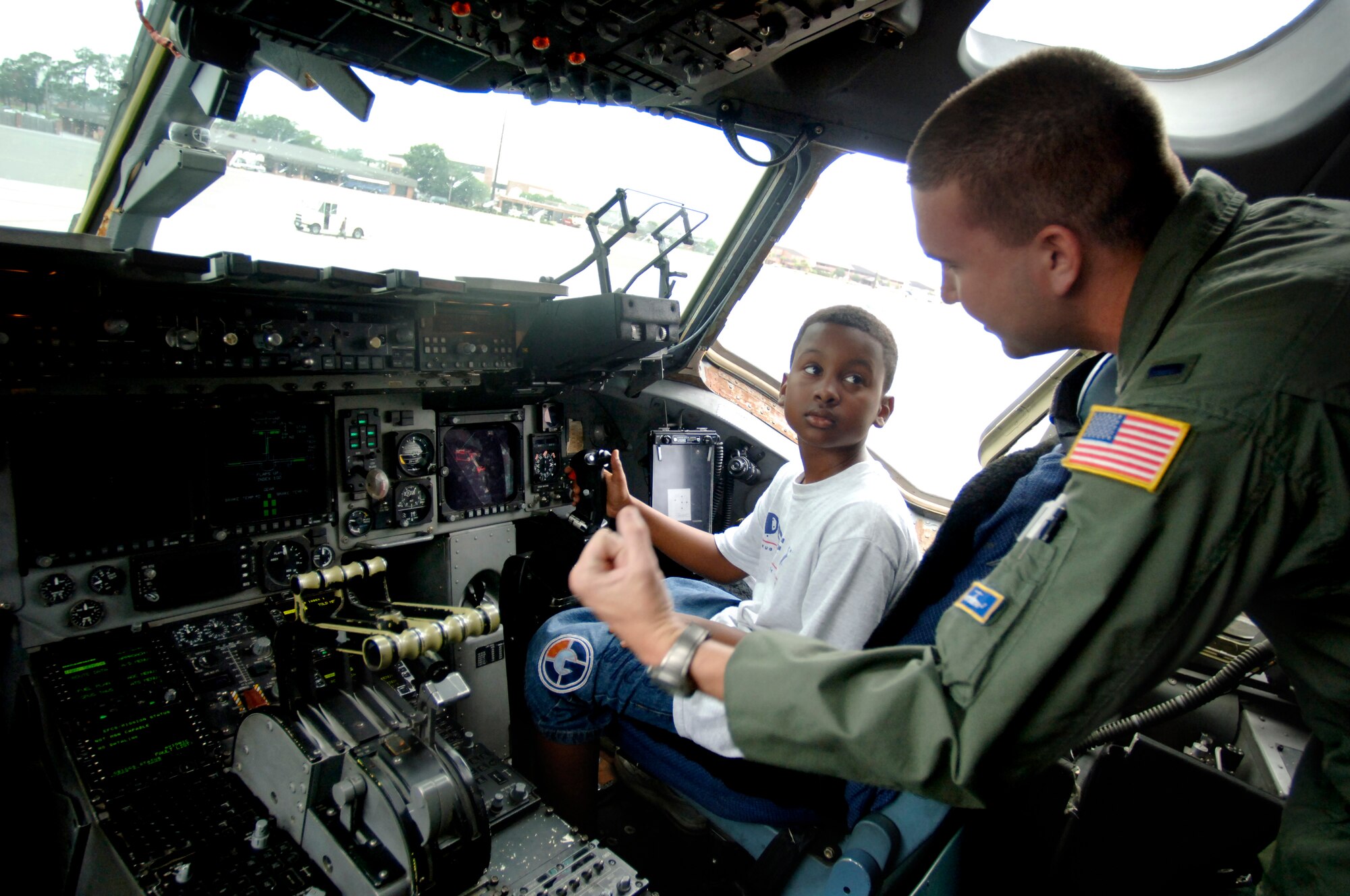 1st Lt. Derek Dupuis, 14th Airlift Squadron pilot, instructs Yancey Wright, 11, son of Staff Sgt. Brian Frances, 437th Aerial Port Squadron passenger travel journeyman, on how the C-17 throttle works June 20 on Charleston's flightline.   (U.S. Air Force photo/Airman 1st Class Nicholas Pilch) 
