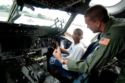 1st Lt. Derek Dupuis, 14th Airlift Squadron pilot, instructs Yancey Wright, 11, son of Staff Sgt. Brian Frances, 437th Aerial Port Squadron passenger travel journeyman, on how the C-17 throttle works June 20 on Charleston's flightline.   (U.S. Air Force photo/Airman 1st Class Nicholas Pilch) 