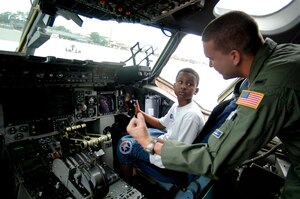 1st Lt. Derek Dupuis, 14th Airlift Squadron pilot, instructs Yancey Wright, 11, son of Staff Sgt. Brian Frances, 437th Aerial Port Squadron passenger travel journeyman, on how the C-17 throttle works June 20 on Charleston's flightline.   (U.S. Air Force photo/Airman 1st Class Nicholas Pilch) 
