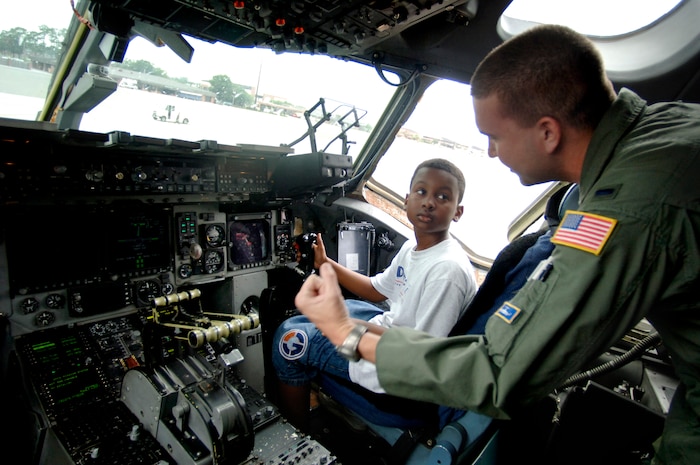 1st Lt. Derek Dupuis, 14th Airlift Squadron pilot, instructs Yancey Wright, 11, son of Staff Sgt. Brian Frances, 437th Aerial Port Squadron passenger travel journeyman, on how the C-17 throttle works June 20 on Charleston's flightline.   (U.S. Air Force photo/Airman 1st Class Nicholas Pilch) 