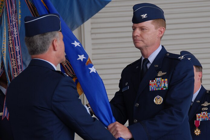 Col. John "Red" Millander, incoming commander to the 437th Airlift Wing, assumes command from Maj. Gen. James Hawkins, 18th Air Force commander, during the official change of command ceremony held in Nose Dock 2 at Charleston AFB Monday. (U.S. Air Force photo/Senior Airman Sam Hymas)