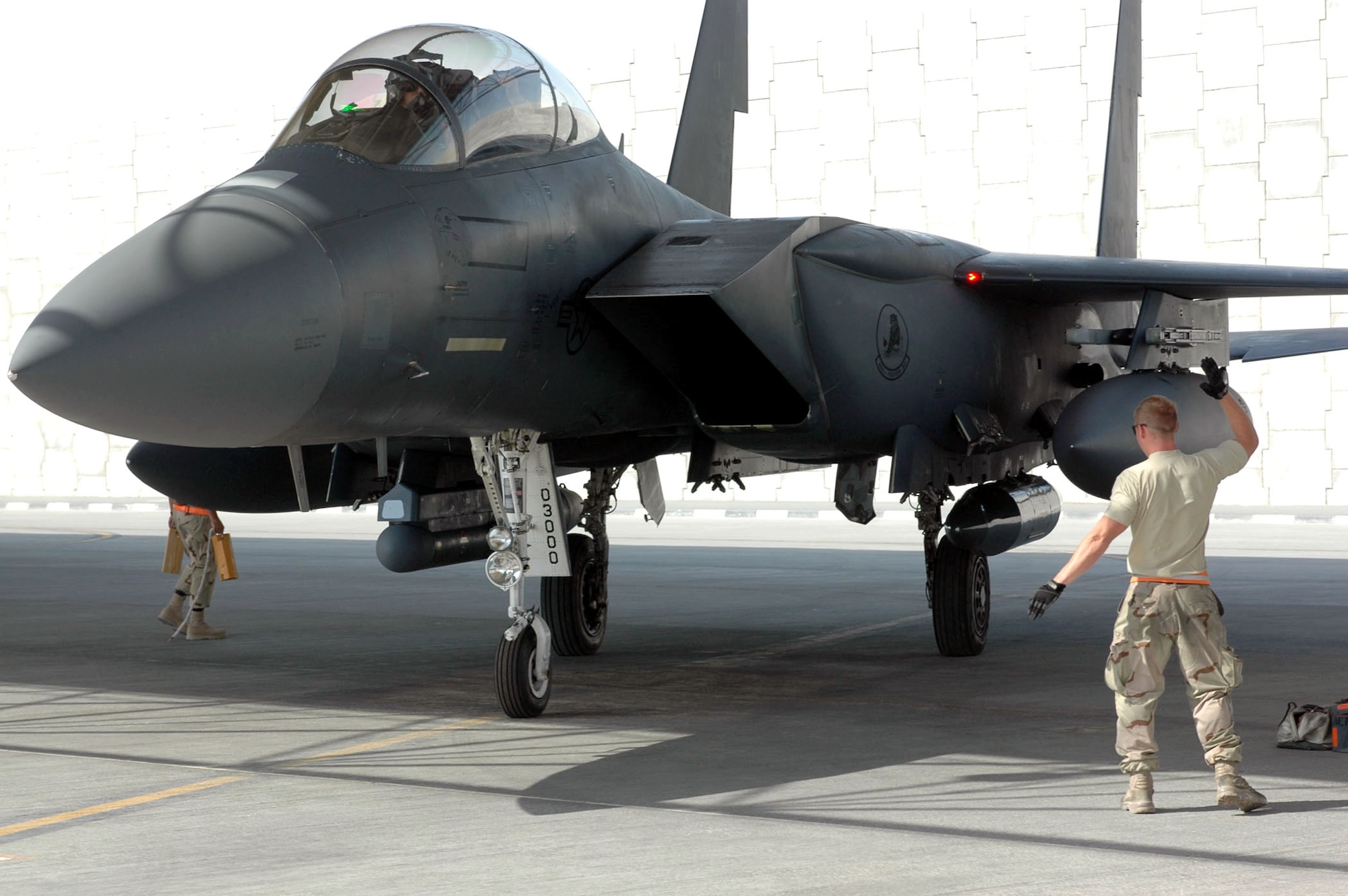 An Air Force F-15E Strike Eagle crew chief guides his aircraft into position at a base in Southwest Asia after a close-air-support mission.  F-15Es were part of the 30 coalition close-air-support missions flown in Afghanistan June 26. (U.S. Air Force photo.)