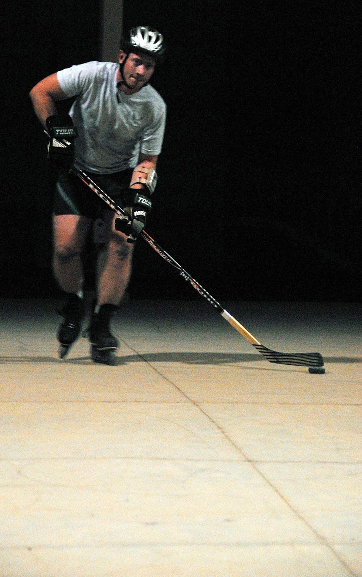 After working a 12-hour shift, Tech. Sgt. Wayland J. Baker is ready to hit the "ice."The father of six is serving a four-month deployment in support of operations Iraqi and Enduring Freedom. After a long day driving vehicles on the hot tarmac he enjoys playing solitaire hockey. The Corinth, N.Y., native deployed from the 116th Logistics Readiness Squadron, Robins Air Force Base, Ga., is assigned to the 386th Expeditionary Logistics Readiness Squadron. (U.S. Air Force photo/Tech. Sgt. Scott Moorman) 
