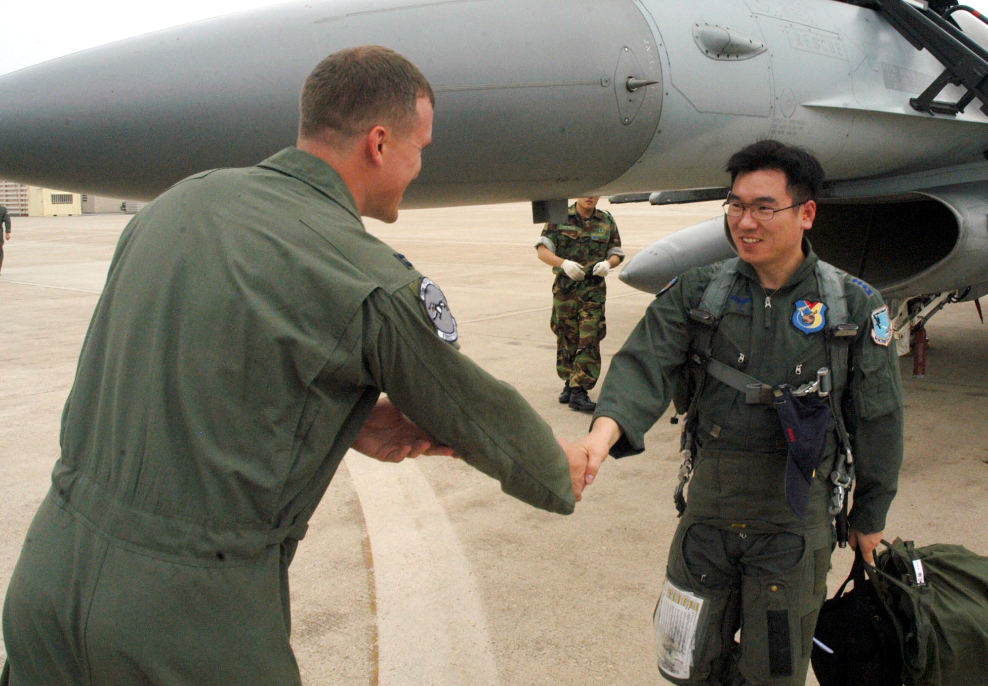 Capt. Scott Johnson greets South Korean air force Capt. Yeon, Sang Mo during the 35th Fighter Squadron's quarterly Buddy Wing Program June 27 at Kunsan Air Base, South Korea. The exchange program allows American and South Korean pilots to learn about each other's flying operations to better operate in the event of hostilities on the peninsula. Captain Johnson is a pilot with the 35th FS. (U.S. Air Force photo/Senior Airman Stephen Collier) 
