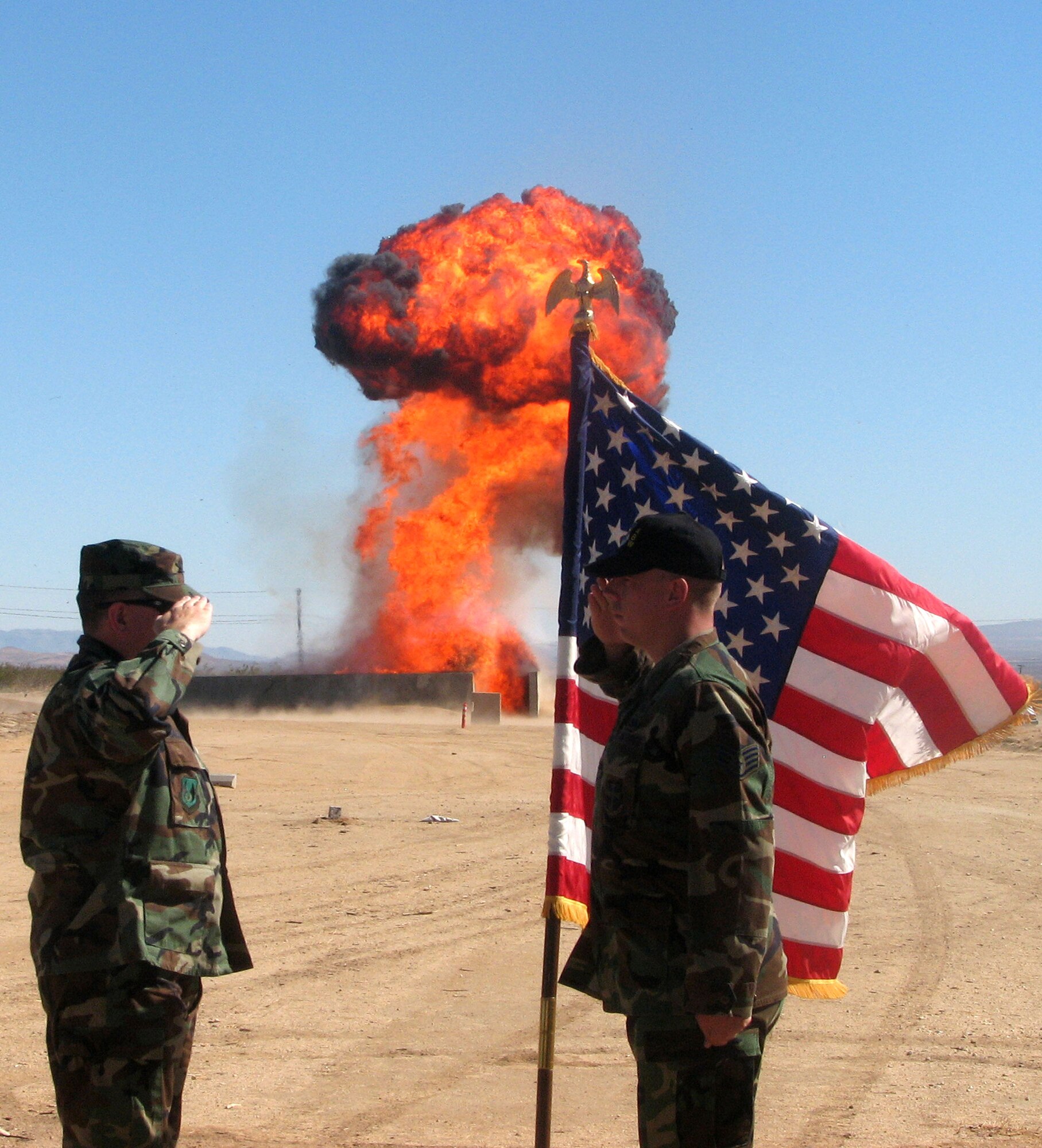 Staff Sgt. Brian Boisselle (right), Explosive Ordnance Disposal equipment noncommissioned officer in charge, renders a salute to Col. Bryan Gallagher (left), 95th Air Base Wing commander, during his re-enlistment ceremony at the EOD proficiency range June 20. As a tradition, EOD usually gives their Airmen a fireworks display during their re-enlisment ceremony. (Photo by Senior Airman Michael Werre)