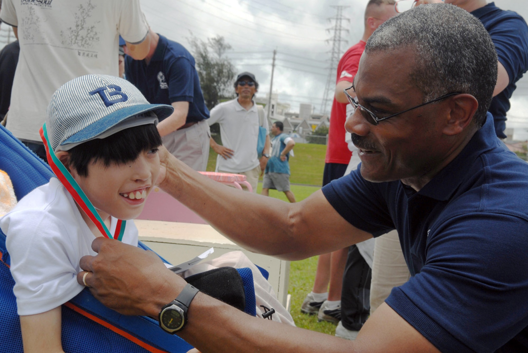 Yujiro Nakamura of the Awase Special Needs School receives his silver medal from Chief Master Sgt. Jack Johnson Jr. after competing in the softball throw event during the 2007 Special Olympic Games June 24 at Kadena Air Base, Japan. More than 1,500 people volunteered in this year's Special Olympics at Kadena AB. Chief Johnson is the 18th Wing command chief. (U.S. Air Force photo/Senior Airman Jeremy McGuffin)